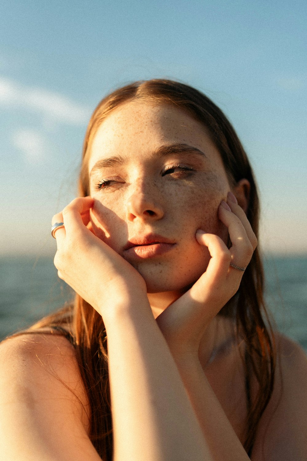 a woman with freckled hair and a ring on her finger