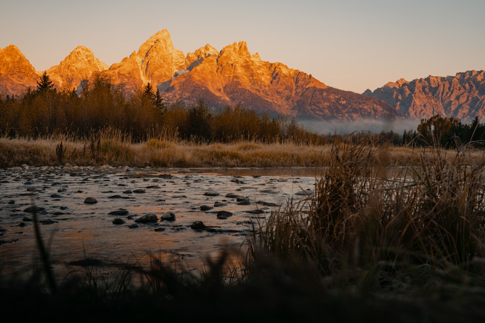 the sun is setting on a mountain range