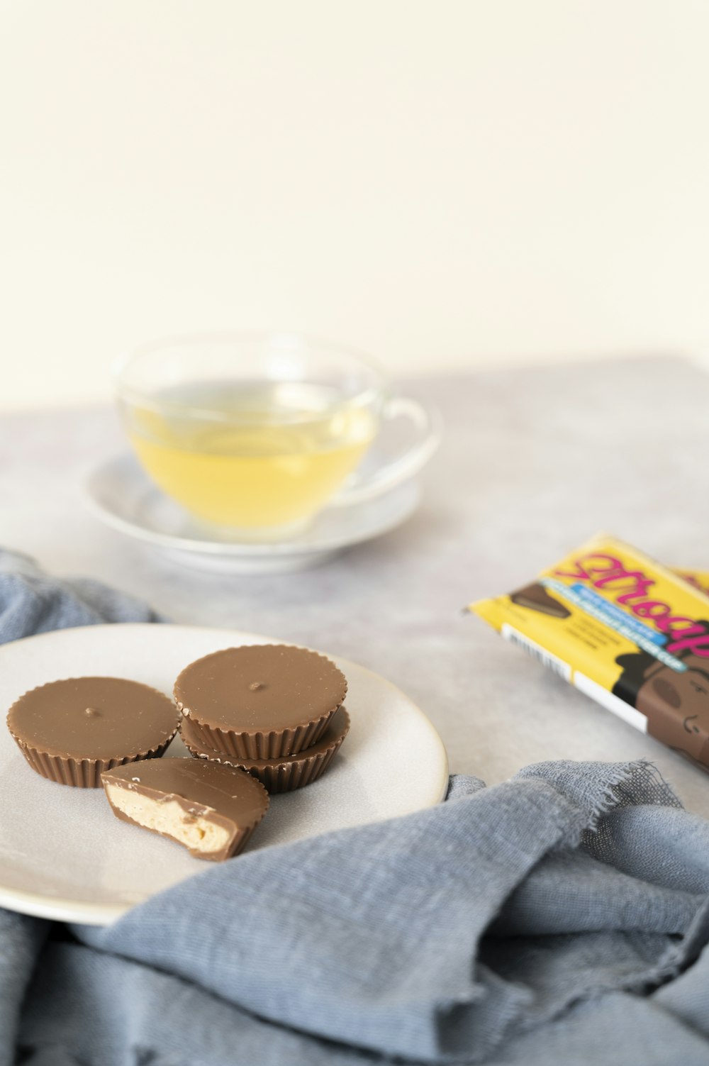 a plate of peanut butter cups next to a cup of tea