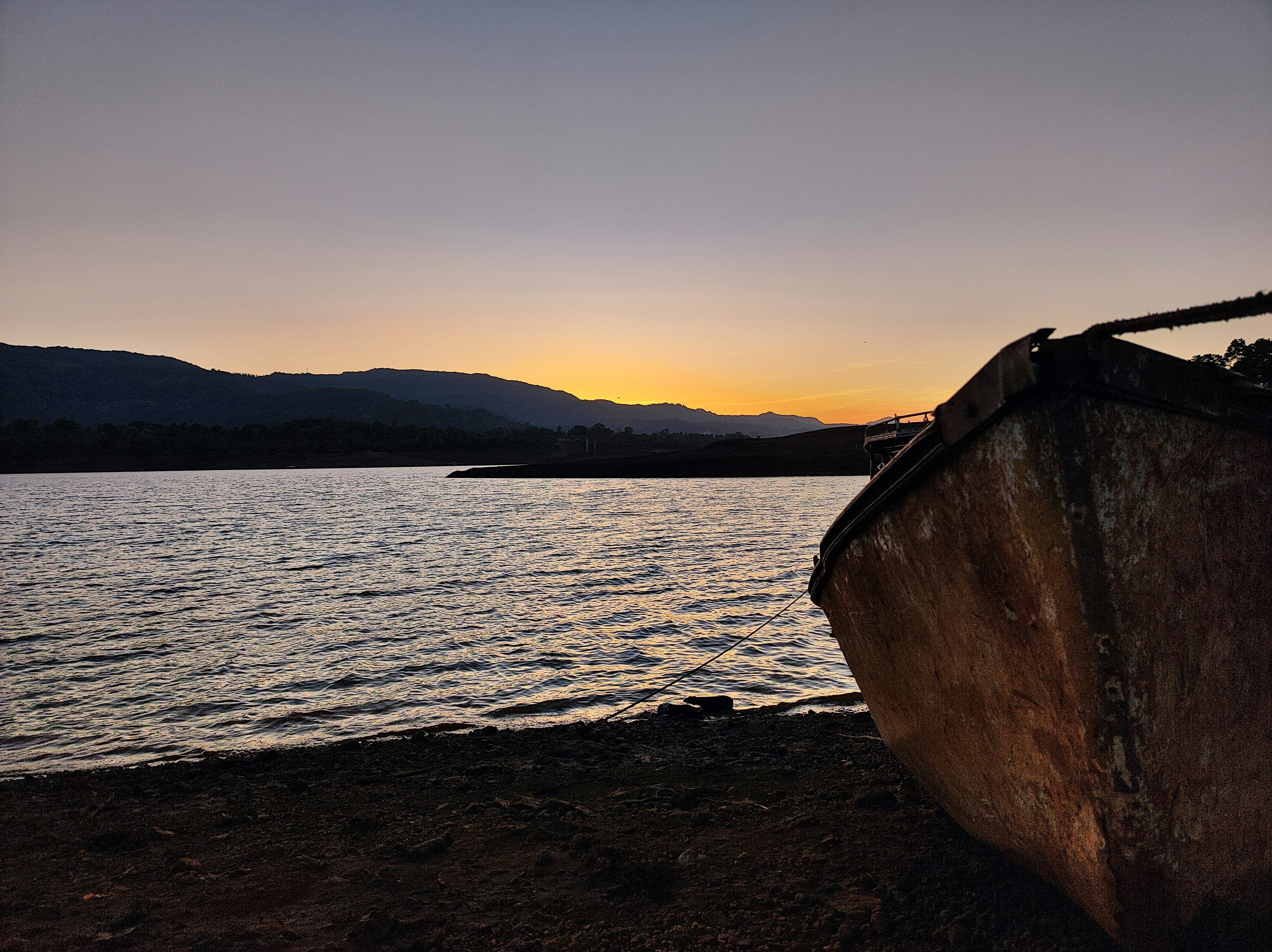a boat sitting on top of a beach next to a body of water