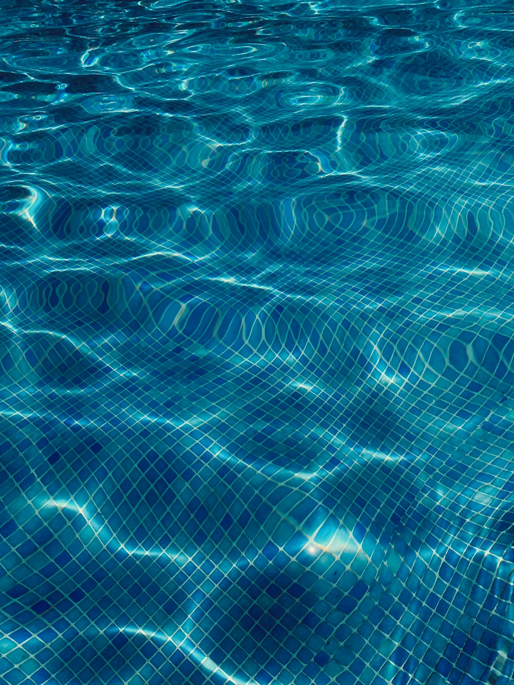 a swimming pool with blue water and ripples