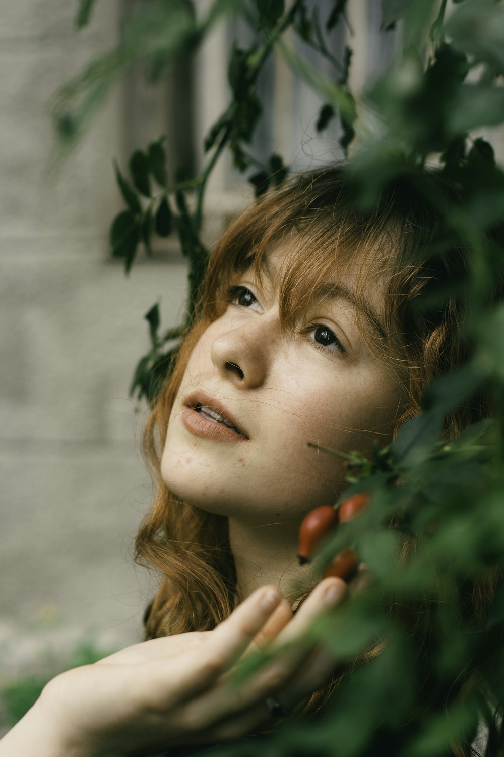 a woman with red hair is looking up at something