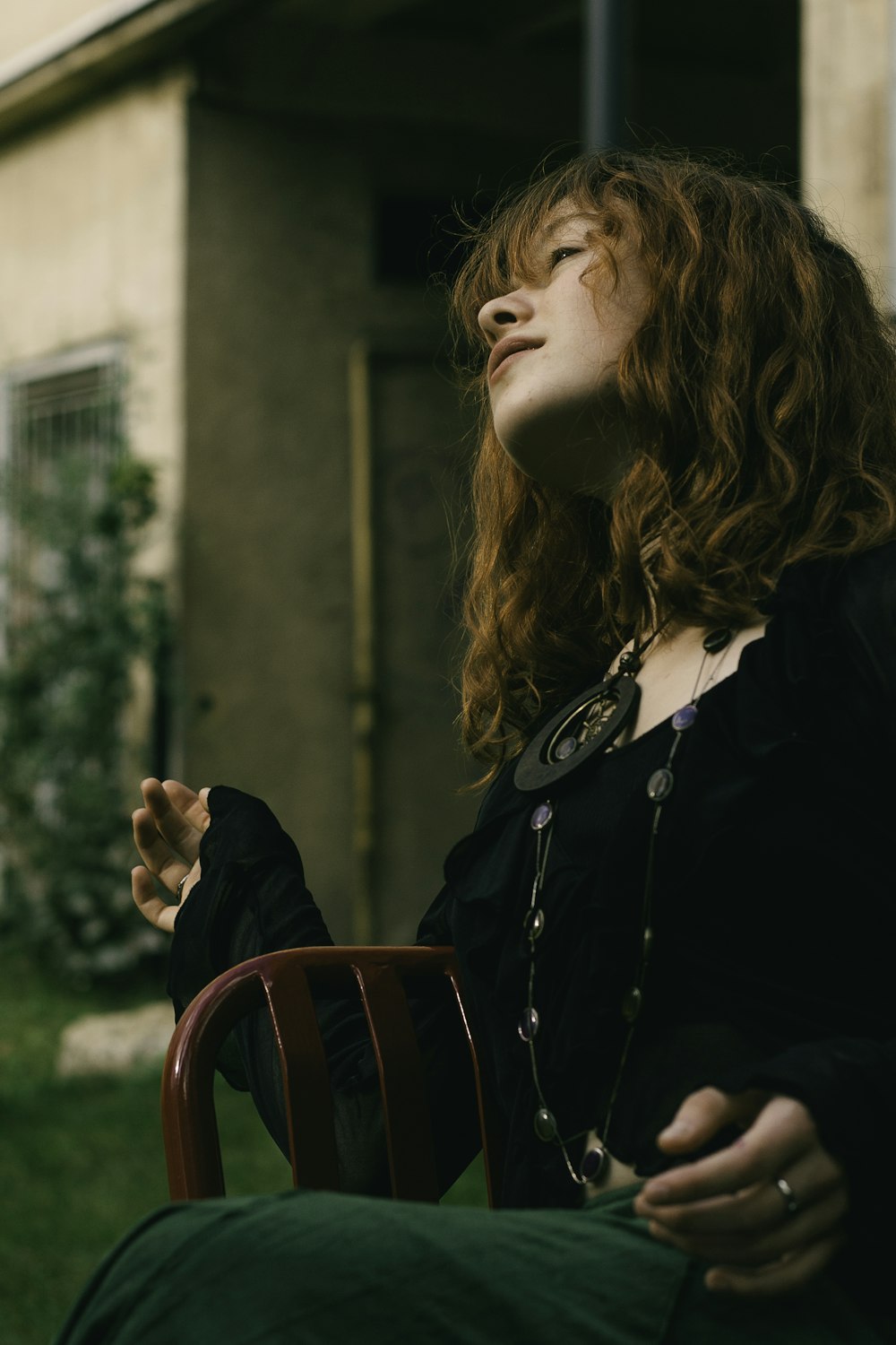 a woman sitting on top of a wooden chair