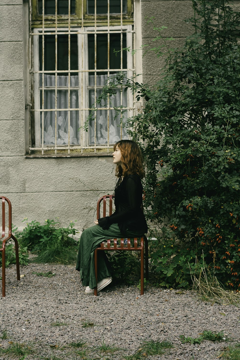 a woman sitting on a chair in front of a window