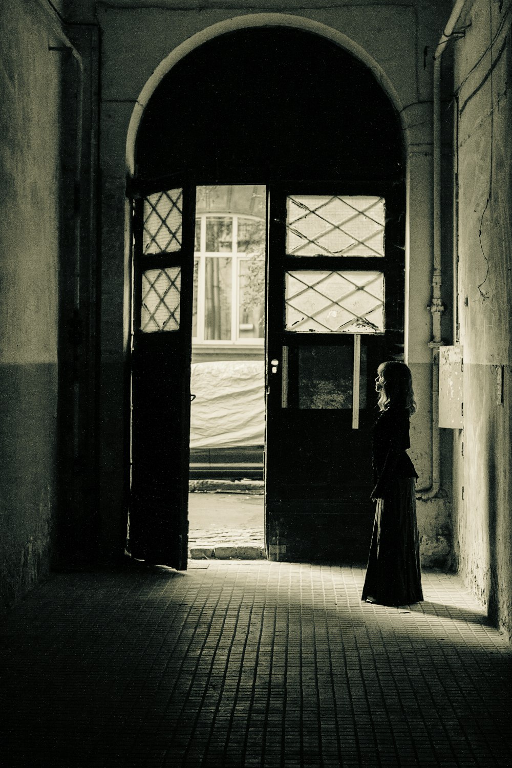 a woman in a long dress standing in a doorway