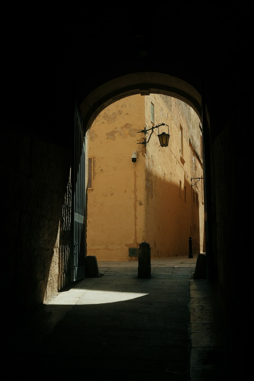 a dark alley way with an iron gate