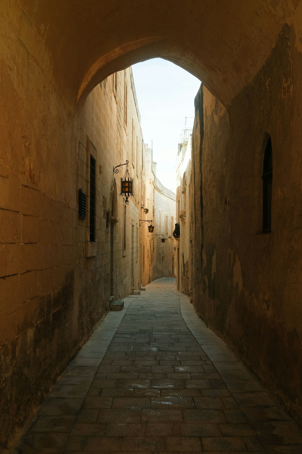 eine schmale Gasse mit Steingebäuden und Kopfsteinpflaster