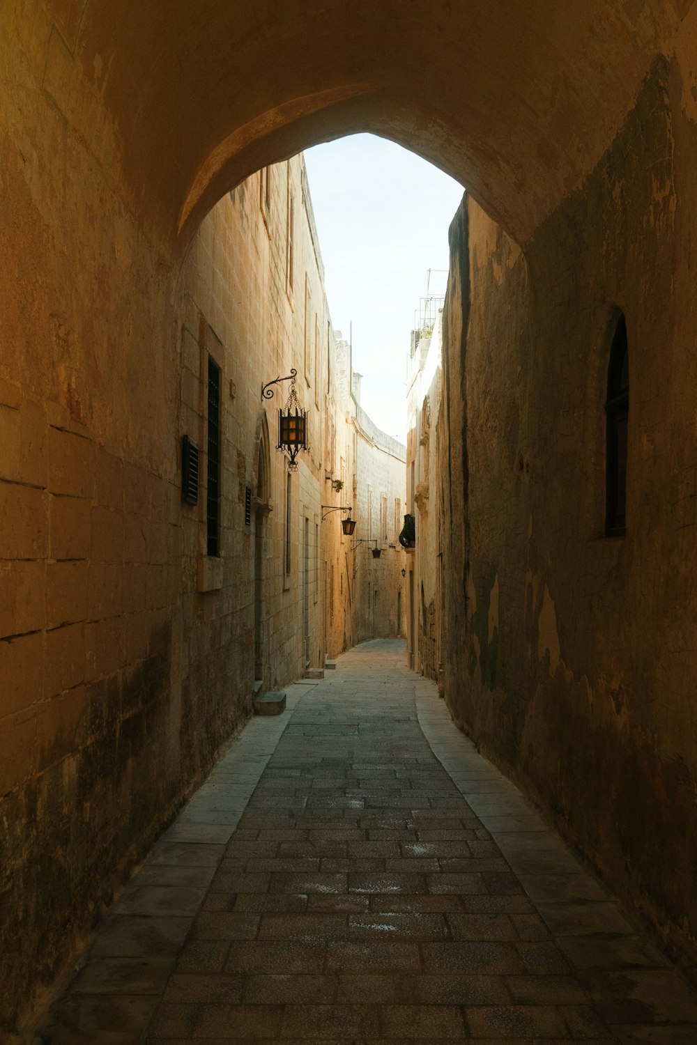a narrow alley way with stone buildings and cobblestones