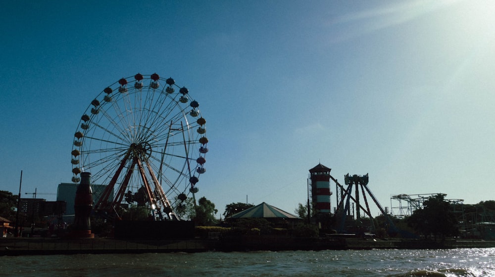 a ferris wheel sitting next to a body of water