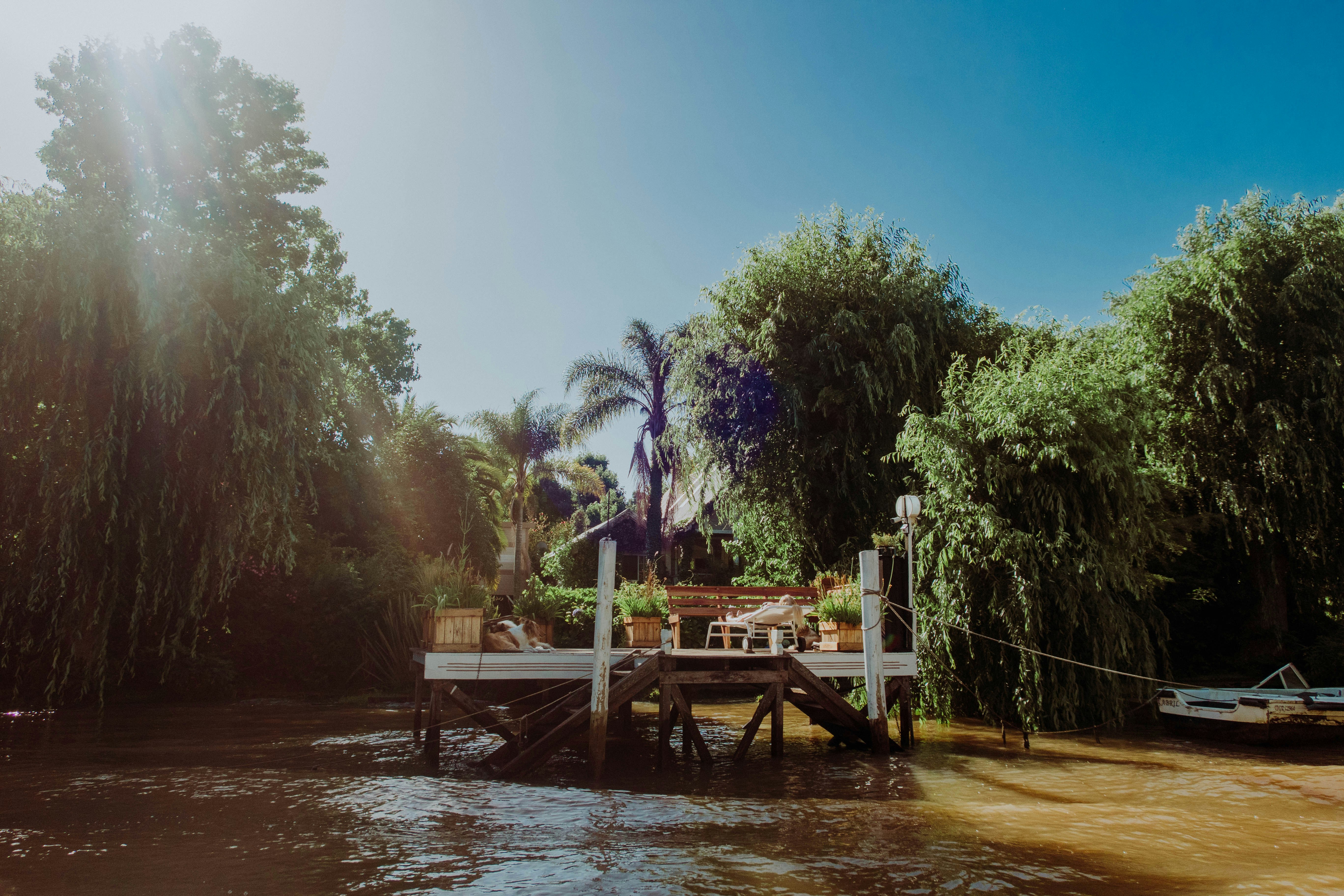 a dock on the side of a river surrounded by trees