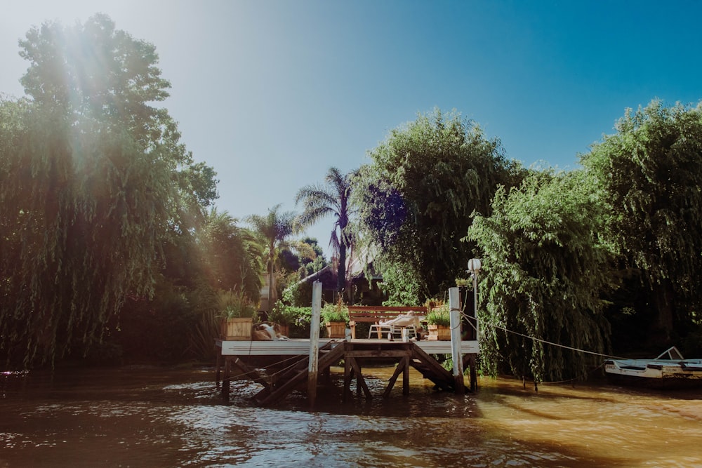 a dock on the side of a river surrounded by trees