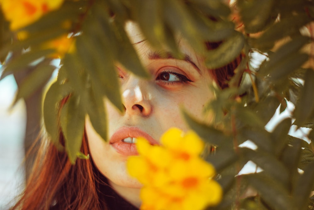 a woman with red hair and a yellow flower in her hand