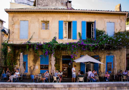 A cozy café terrace in Marseille where people casually meet and chat.