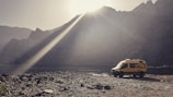 A vibrant yellow campervan parked in a scenic landscape.