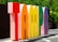Large, colorful three-dimensional letters spell out the word 'Tampa' in an outdoor setting, with greenery in the background and bright sunlight casting shadows.