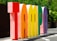 Large, colorful three-dimensional letters spell out the word 'Tampa' in an outdoor setting, with greenery in the background and bright sunlight casting shadows.
