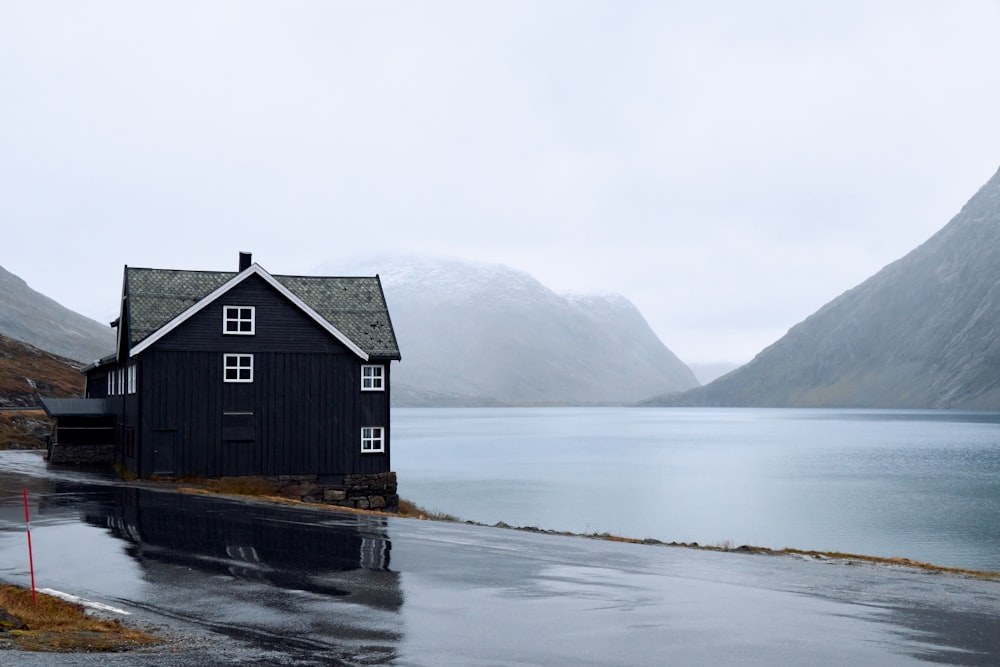 a house sitting on the side of a road next to a body of water