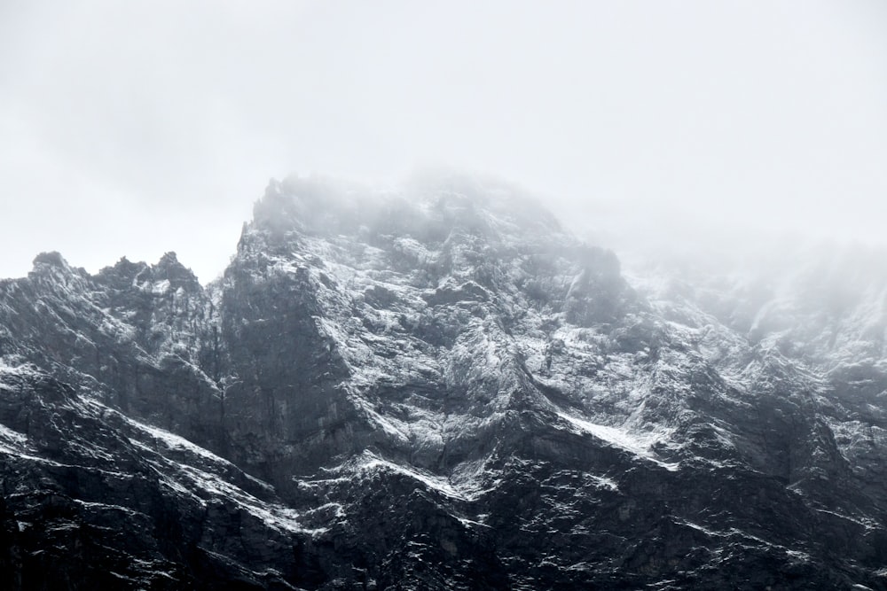 a very tall mountain covered in snow on a cloudy day