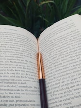 An open book with a quill pen resting beside it, symbolizing creativity and storytelling.