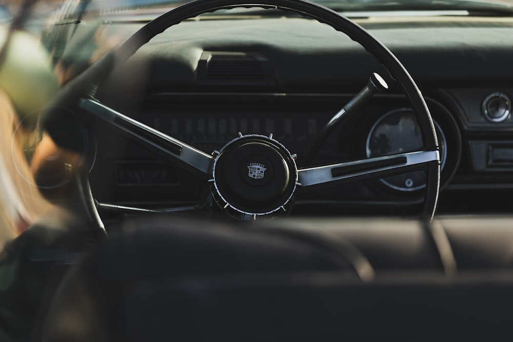 a woman sitting in a car with a steering wheel