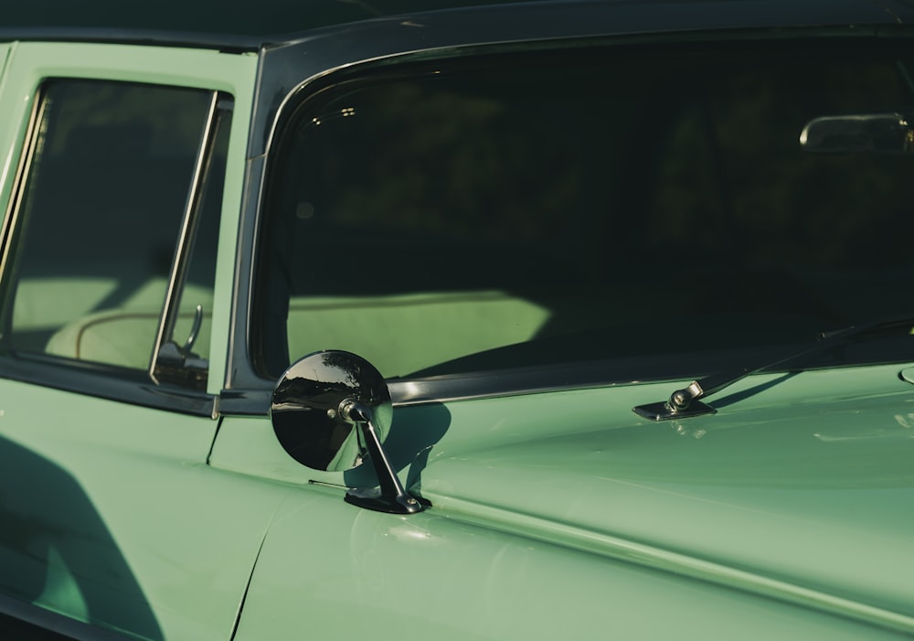 a close up of the side mirror of a green car