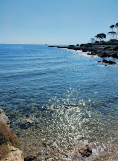 Sunlight sparkling on the crystal-clear waters of a hidden beach near Costa Smeralda.