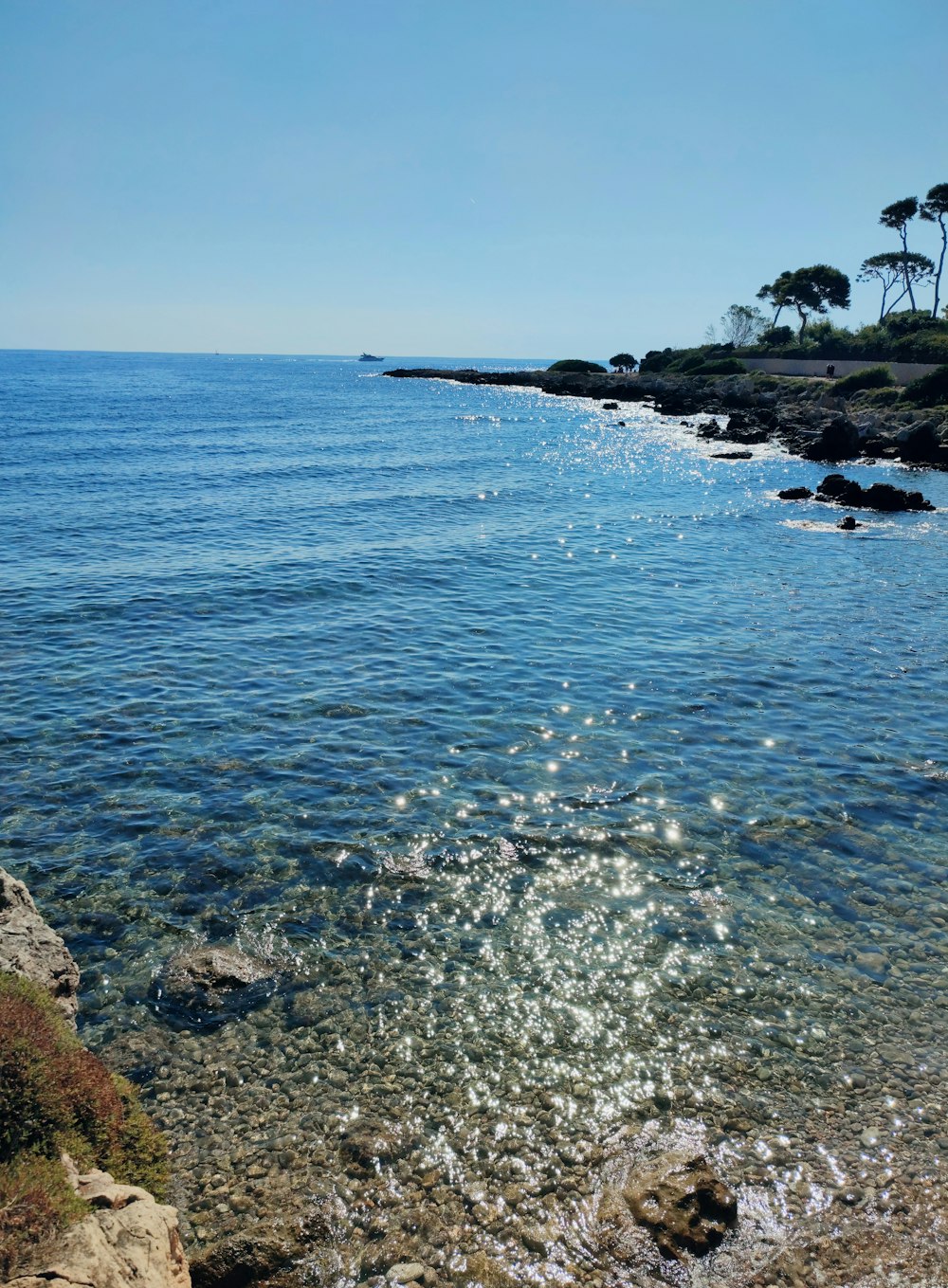 a body of water sitting next to a rocky shore