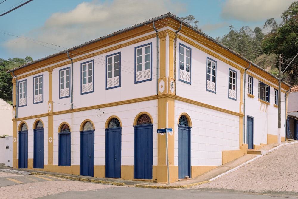 um edifício amarelo e branco com persianas azuis