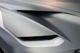 Close-up of a sleek car body kit with sharp, modern lines in a workshop setting.