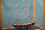 A detailed close-up of a wooden model ship's sail and rigging.