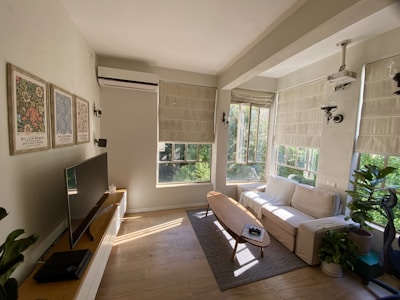 A modern living room with pleated insect screens elegantly installed on large windows.