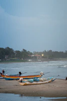 Traditional fishing boats resting on the sandy shores of Luanda.