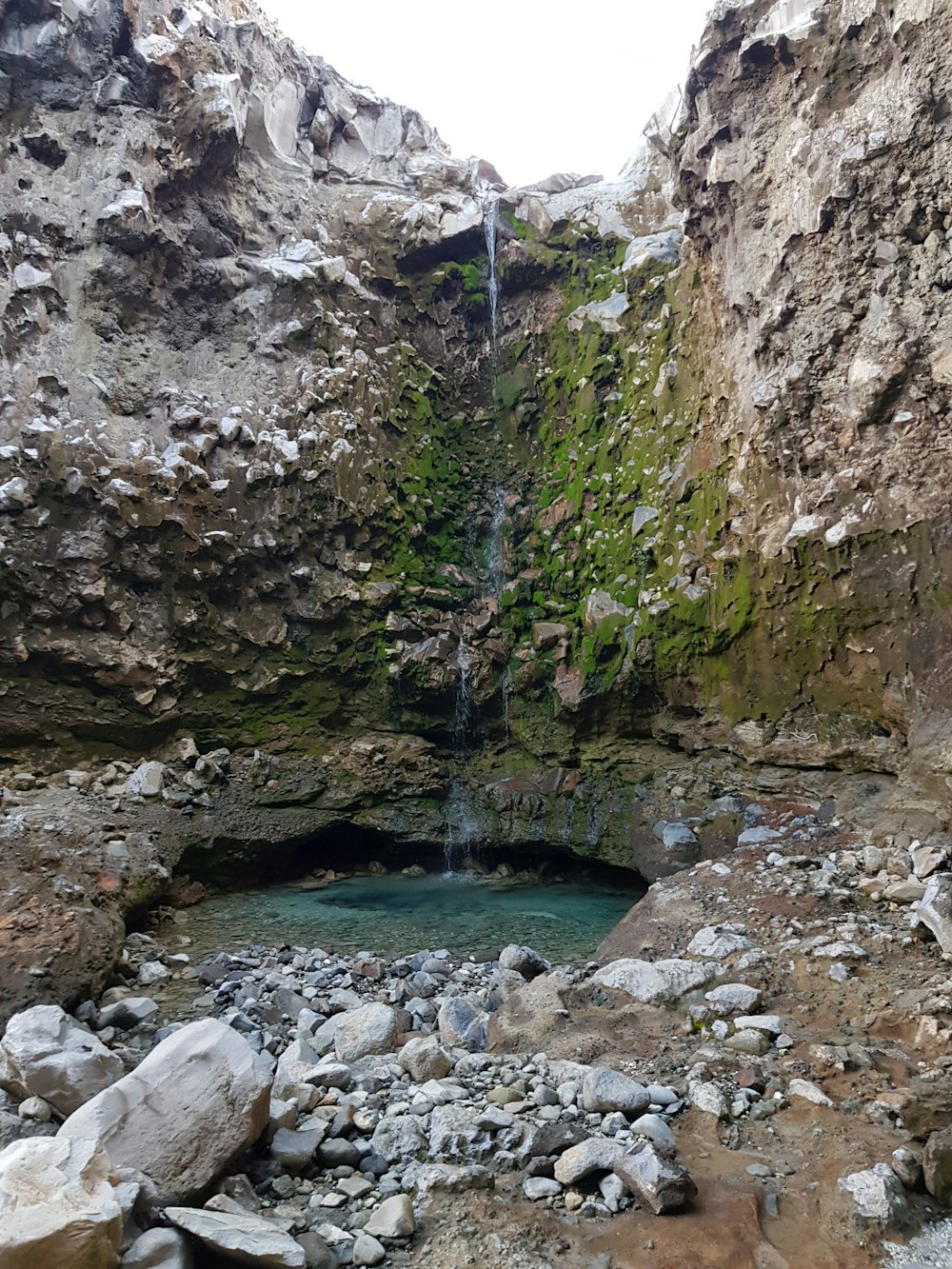 a small waterfall in the middle of a rocky area