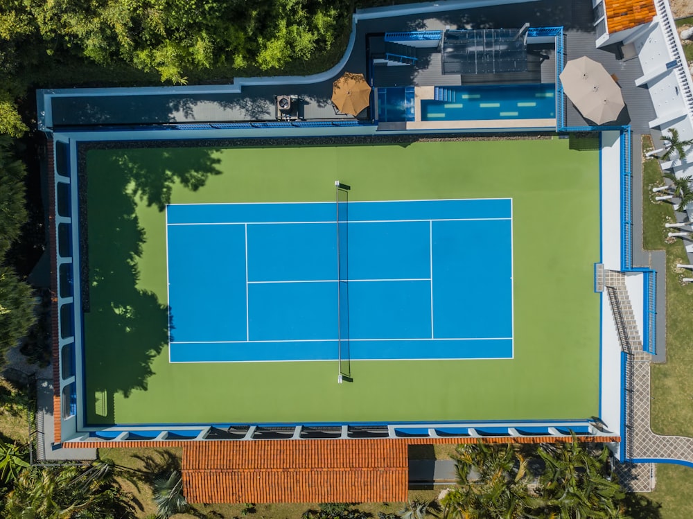 an aerial view of a tennis court in the middle of a park