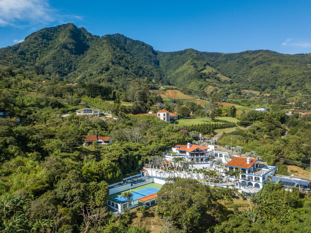an aerial view of a mansion surrounded by lush green hills