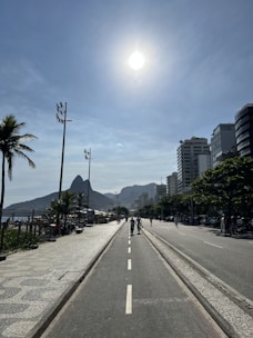A sunlit street in the Inland Empire with palm trees and mountains in the background.