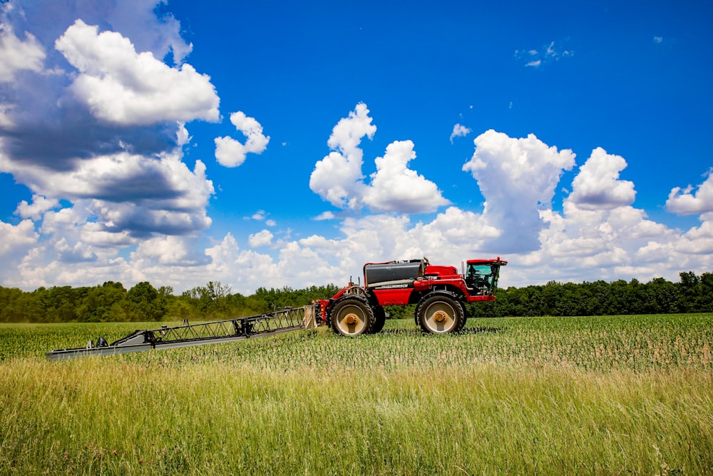 a tractor pulling a trailer behind it through a field