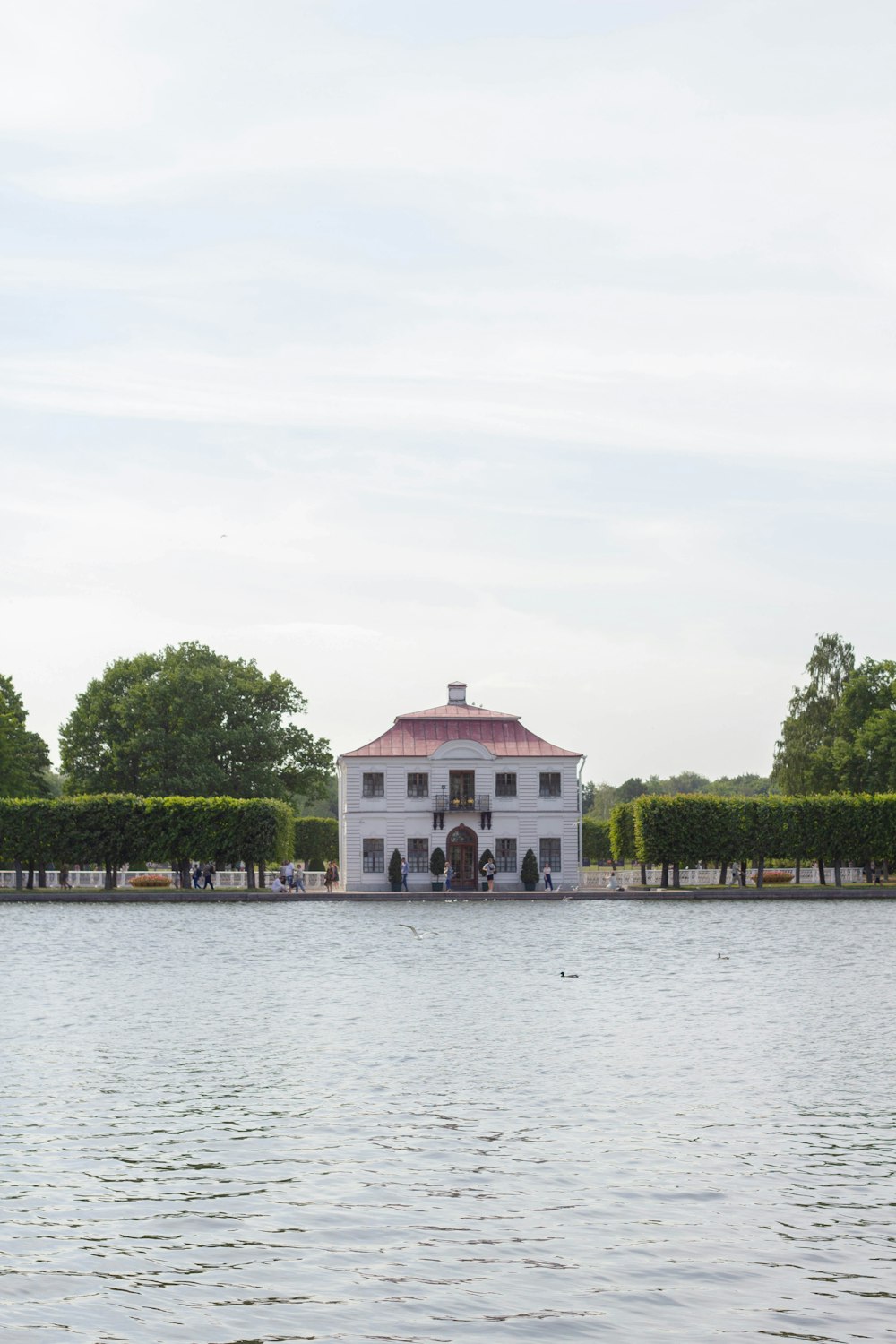 uma grande casa branca sentada no topo de um lago