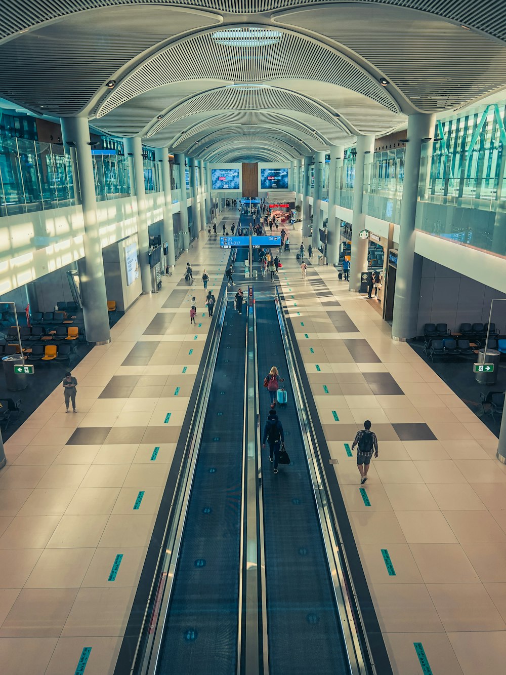 a train station with people riding on the escalators