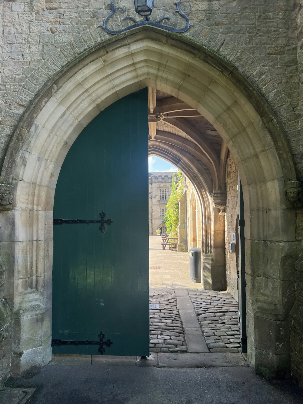 a green door is open in a stone building