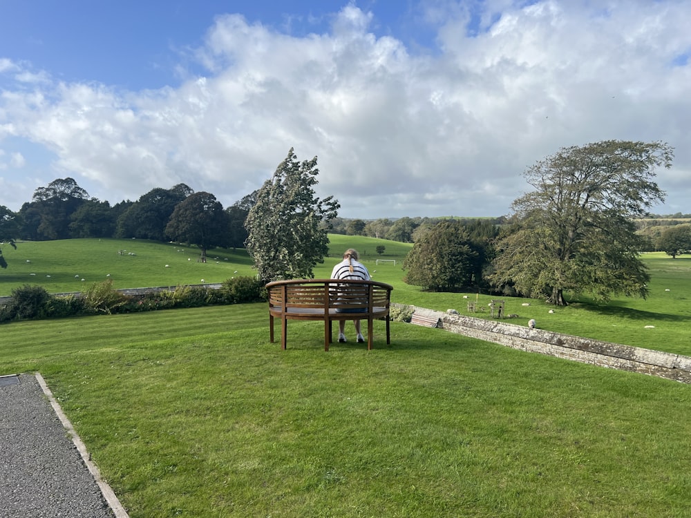 a man sitting on a bench in a park