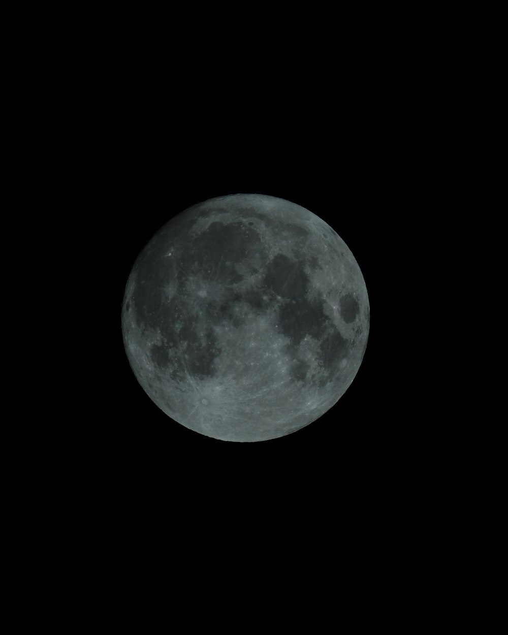 a full moon is seen in the dark sky