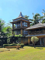Cozy family chalet exterior nestled among palm trees under a clear blue sky in Muscat.