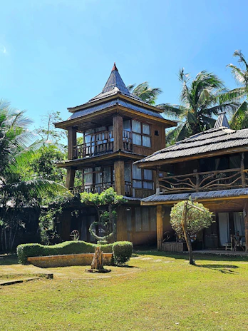Cozy family chalet exterior nestled among palm trees under a clear blue sky in Muscat.