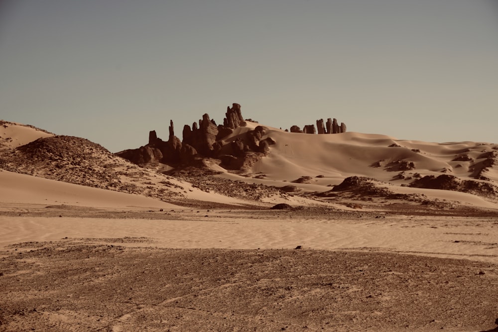 a desert landscape with rocks and sand dunes