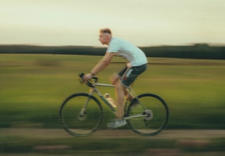 a man riding a bike down a dirt road