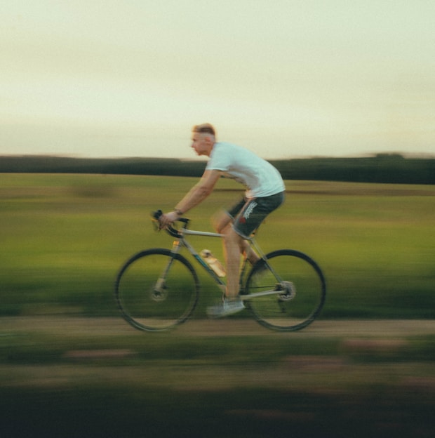 a man riding a bike down a dirt road