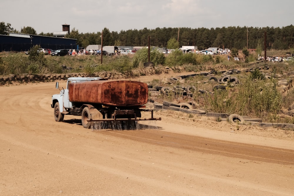 a truck is driving down a dirt road