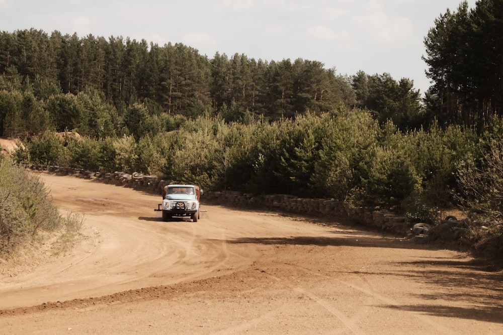 a truck is driving down a dirt road