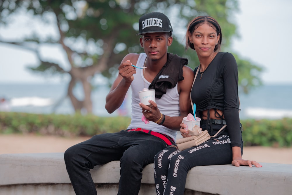 a man and a woman sitting on a wall